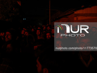 People watch as firefighters try to douse the flames after a fire breaks out in the industrial area of Sopore, Jammu and Kashmir, India, on...