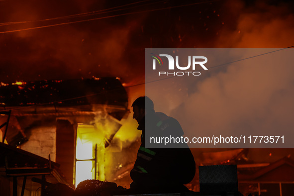 Firefighters try to douse the flames after a fire breaks out in the industrial area of Sopore, Jammu and Kashmir, India, on November 13, 202...