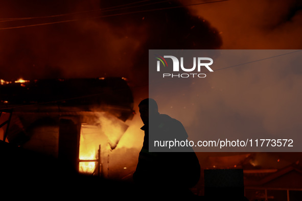 Firefighters try to douse the flames after a fire breaks out in the industrial area of Sopore, Jammu and Kashmir, India, on November 13, 202...