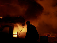 Firefighters try to douse the flames after a fire breaks out in the industrial area of Sopore, Jammu and Kashmir, India, on November 13, 202...