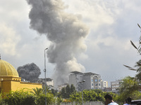 Smoke rises among the residential buildings following an Israeli attack on Ghobeiry municipality located in the Dahieh region in Beirut, Leb...