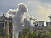 Smoke rises among the residential buildings following an Israeli attack on Ghobeiry municipality located in the Dahieh region in Beirut, Leb...