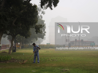 A sweeper works near India Gate as severe pollution levels are recorded in New Delhi, India, on November 13, 2024 (