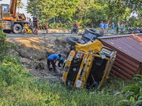 A crane lifts the wrecked accident-covered van beside a highway in Feni, Bangladesh, on November 13, 2024. (