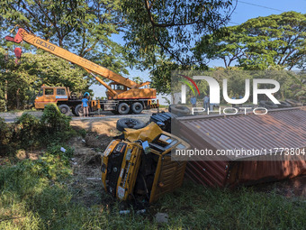 A crane lifts the wrecked accident-covered van beside a highway in Feni, Bangladesh, on November 13, 2024. (