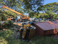 A crane lifts the wrecked accident-covered van beside a highway in Feni, Bangladesh, on November 13, 2024. (