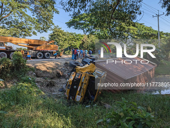 A crane lifts the wrecked accident-covered van beside a highway in Feni, Bangladesh, on November 13, 2024. (