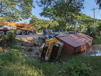 A crane lifts the wrecked accident-covered van beside a highway in Feni, Bangladesh, on November 13, 2024. (