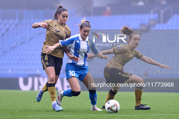 Nahia Aparicio and Ane Etxezarreta of Real Sociedad compete for the ball with Millene Cabral of RC Deportivo Abanca during the Liga F match...