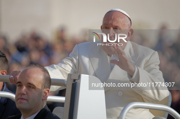 Pope Francis greets the crowd as he arrives for his weekly General Audience in Saint Peter's Square, Vatican City, on November 13, 2024. 