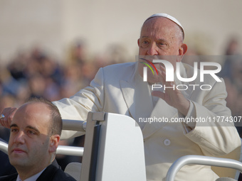 Pope Francis greets the crowd as he arrives for his weekly General Audience in Saint Peter's Square, Vatican City, on November 13, 2024. (