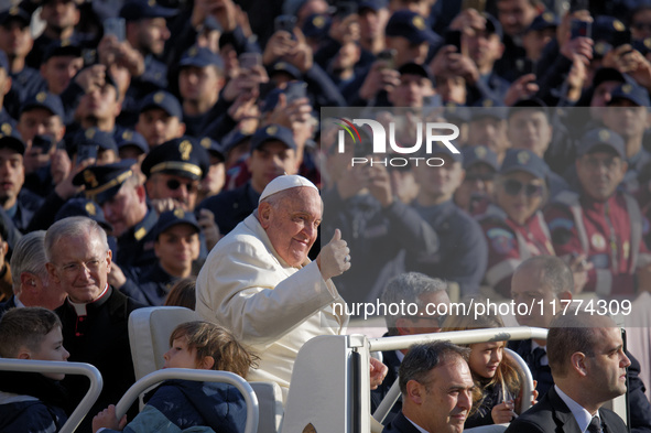 Pope Francis greets the crowd as he arrives for his weekly General Audience in Saint Peter's Square, Vatican City, on November 13, 2024. 