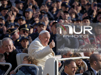 Pope Francis greets the crowd as he arrives for his weekly General Audience in Saint Peter's Square, Vatican City, on November 13, 2024. (