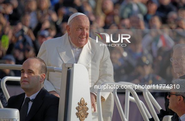 Pope Francis greets the crowd as he arrives for his weekly General Audience in Saint Peter's Square, Vatican City, on November 13, 2024. 