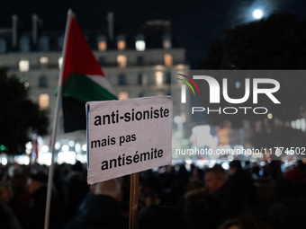 A protester holds a placard reading ''Anti-Zionist but not anti-Semitic'' during a rally organized by political parties (La France Insoumise...