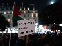 A protester holds a placard reading ''Anti-Zionist but not anti-Semitic'' during a rally organized by political parties (La France Insoumise...