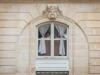 In Paris, France, on November 13, 2024, two members of the staff of the Elysee Palace pull back the curtains, peer through a window, and gaz...