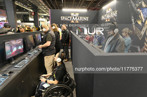 Visitors and gamers play the game ''Warhammer 40,000: Space Marine,'' developed by Relic Entertainment and published by THQ, at the ''Paris...