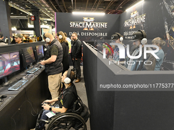 Visitors and gamers play the game ''Warhammer 40,000: Space Marine,'' developed by Relic Entertainment and published by THQ, at the ''Paris...