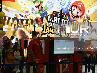 Visitors and gamers play the game ''SUPER MARIO'' at the Nintendo stand during the ''Paris Games Week'' video-game fair in Paris, France, on...