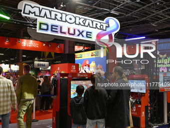 Visitors and gamers play the game ''MARIOKART'' at the Nintendo stand during the ''Paris Games Week'' video-game fair in Paris, France, on O...