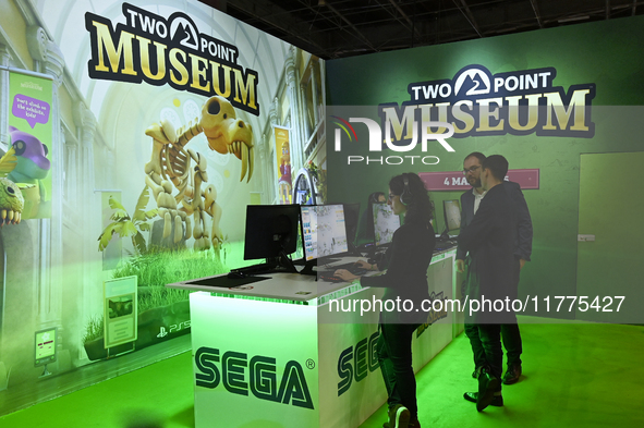 Visitors and gamers play the game ''Two Point Museum,'' developed by Two Point Studios and edited by Sega, at the ''Paris Games Week'' video...