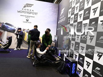 Visitors and gamers play the racing game ''Forza Motorsport,'' edited by Xbox Game Studios, at the ''Paris Games Week'' video-game fair in P...