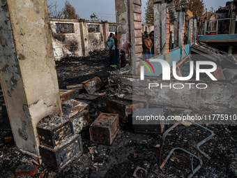 Residents and authorities survey the aftermath of a massive fire that ravages multiple furniture factories in Sopore's Industrial Estate, Ja...