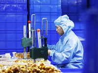 A worker produces new materials for high-end special-shaped anti-counterfeiting bottle caps at a workshop in the Sihong Economic Development...