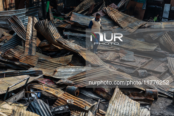 A man surveys the aftermath of a massive fire that ravages multiple factories in Sopore's Industrial Estate, Jammu and Kashmir, India, on No...