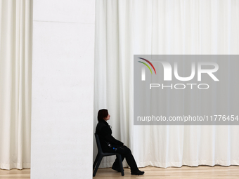 A museum worker sits inside the Modern Art in Warsaw in Warsaw, Poland on November 14, 2024. (