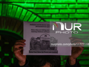 A member of the 'Save Youth Save Future' Foundation holds a candle and placard during a candlelight vigil against the recent grenade blast a...