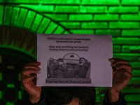 A member of the 'Save Youth Save Future' Foundation holds a candle and placard during a candlelight vigil against the recent grenade blast a...