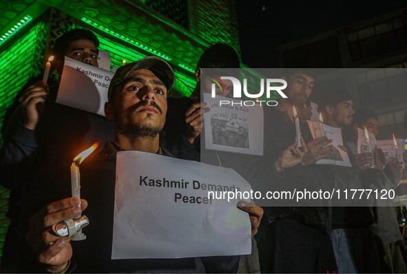 Members of the 'Save Youth Save Future' Foundation hold candles and placards during a candlelight vigil against the recent grenade blast at...