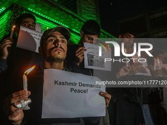 Members of the 'Save Youth Save Future' Foundation hold candles and placards during a candlelight vigil against the recent grenade blast at...