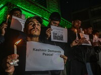 Members of the 'Save Youth Save Future' Foundation hold candles and placards during a candlelight vigil against the recent grenade blast at...