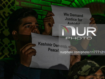 Members of the 'Save Youth Save Future' Foundation hold candles and placards during a candlelight vigil against the recent grenade blast at...