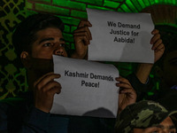 Members of the 'Save Youth Save Future' Foundation hold candles and placards during a candlelight vigil against the recent grenade blast at...