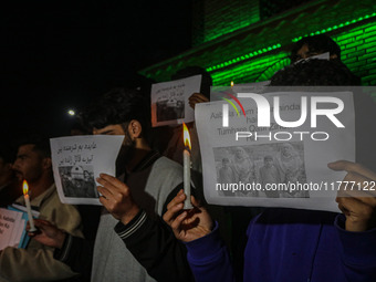 Members of the 'Save Youth Save Future' Foundation hold candles and placards during a candlelight vigil against the recent grenade blast at...