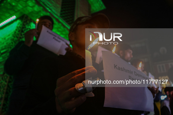 Members of the 'Save Youth Save Future' Foundation hold candles and placards during a candlelight vigil against the recent grenade blast at...