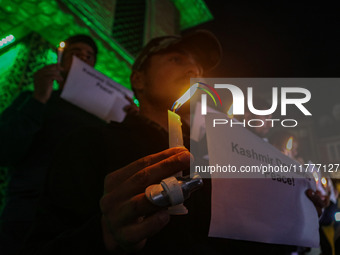 Members of the 'Save Youth Save Future' Foundation hold candles and placards during a candlelight vigil against the recent grenade blast at...