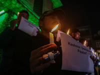 Members of the 'Save Youth Save Future' Foundation hold candles and placards during a candlelight vigil against the recent grenade blast at...