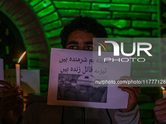 A member of the 'Save Youth Save Future' Foundation holds a candle and placard during a candlelight vigil against the recent grenade blast a...