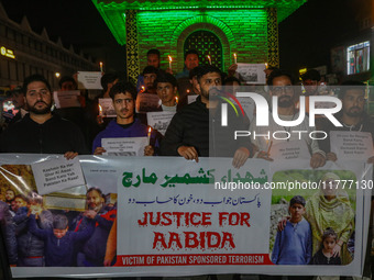 Members of the 'Save Youth Save Future' Foundation hold candles and placards during a candlelight vigil against the recent grenade blast at...