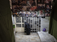 A veiled Iranian woman stands under a banner featuring a portrait of Lebanon's Hezbollah leader, Hassan Nasrallah, who was killed in an Isra...