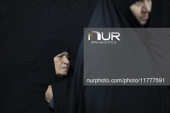 A veiled elderly Iranian woman looks on while participating in a charity ceremony for donating gold and money to help the Lebanese Resistanc...