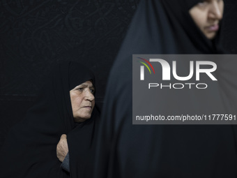 A veiled elderly Iranian woman looks on while participating in a charity ceremony for donating gold and money to help the Lebanese Resistanc...