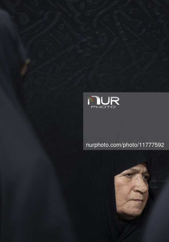 A veiled elderly Iranian woman looks on while participating in a charity ceremony for donating gold and money to help the Lebanese Resistanc...