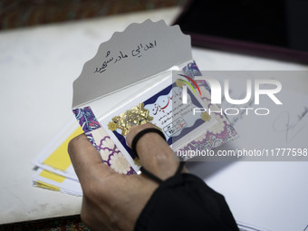 A veiled Iranian woman holds a donated gold plaque with a Persian script on its cover that reads, ''Donated by the martyr's mother,'' during...