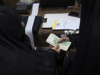 A veiled Iranian woman donates Iranian banknotes during a charity ceremony for donating gold and money to help the Lebanese Resistance Front...